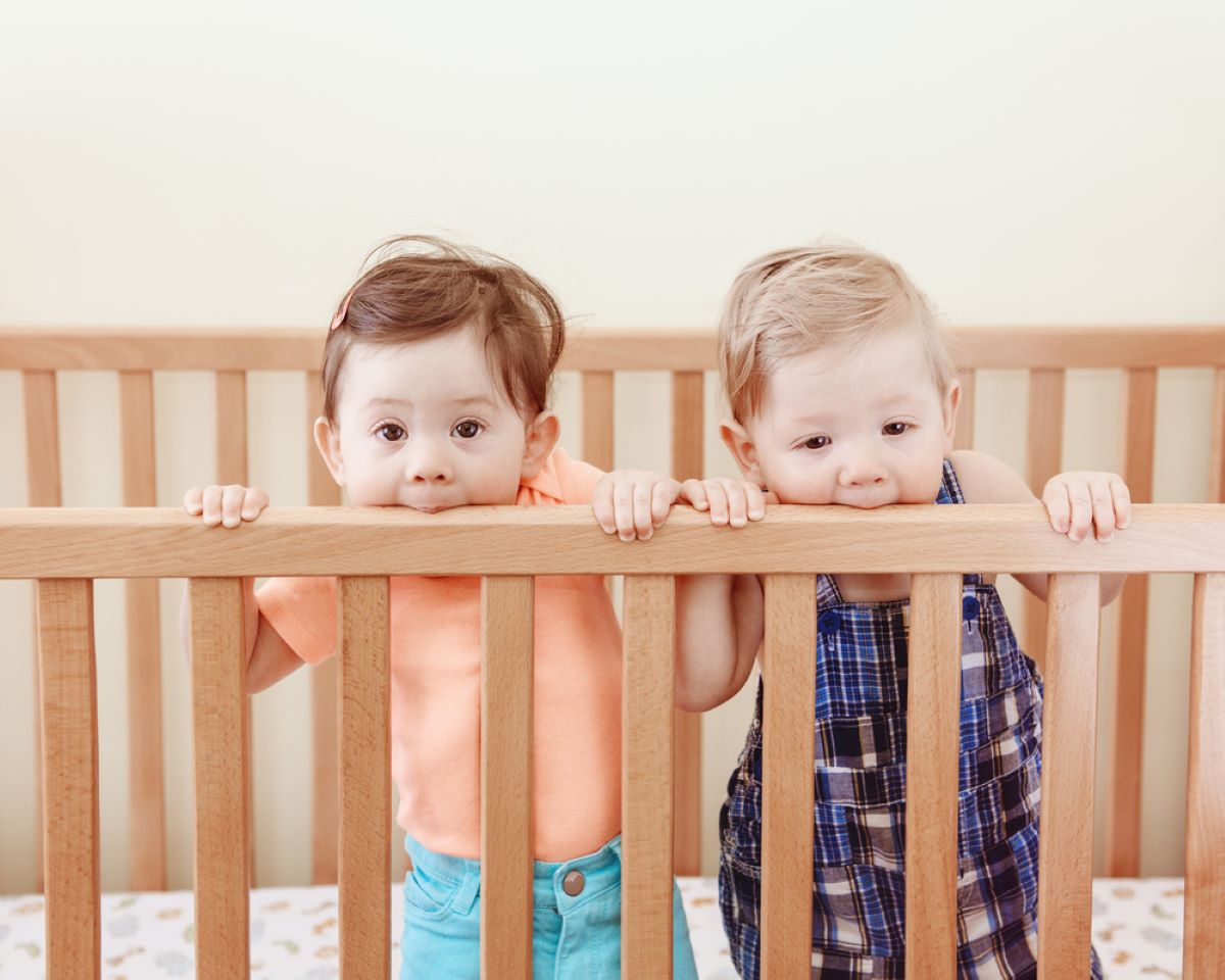 Baby kaut an einem Kinderbett: Spielt es oder zahnt es?