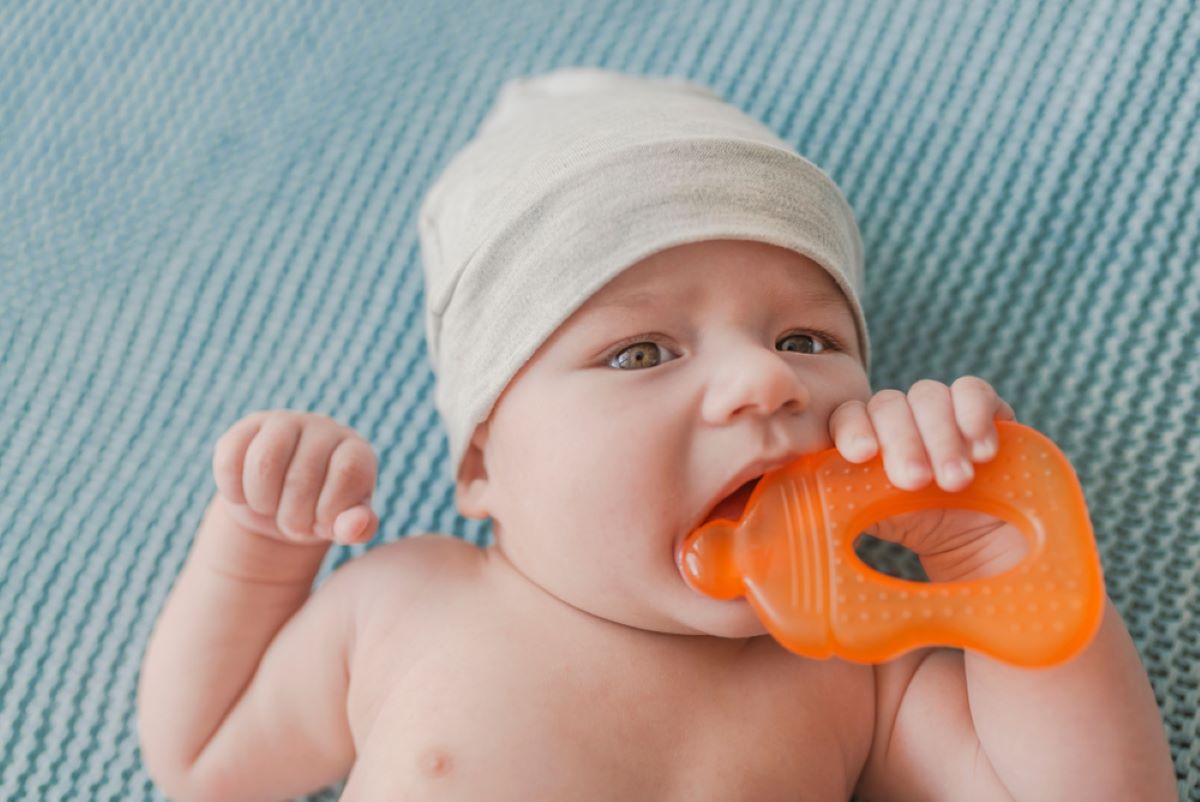 Baby kaut an einem Kinderbett: Spielt es oder zahnt es?